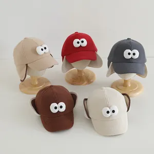 Detailweergave van wintermutsen voor kinderen met oorkleppen en grote oogdecoraties
