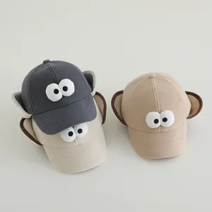 Detail van fleece kindermutsen met cartoon ogen in grijs, kaki en beige voor de winter
