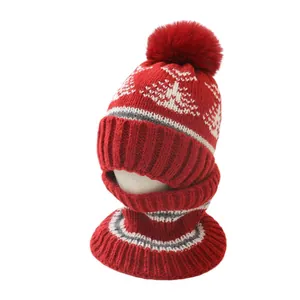 Winter knit hat and scarf set in red with white snowflake patterns and faux fur pompom