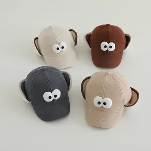 Detail van vier kinderhonkbalpetten met oorkleppen en schattige oogdecoraties