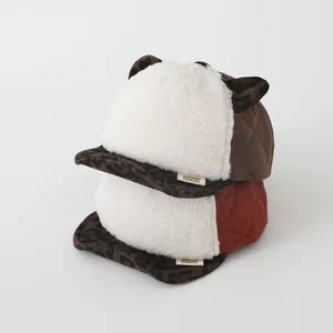 Détail de bonnets d'hiver pour bébés avec oreilles léopard et tissu matelassé
