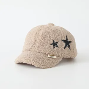Dettaglio del cappello in pile beige con toppe a stella e etichetta decorativa DIDICute
