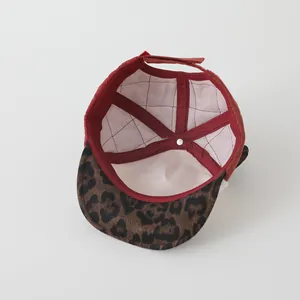 Détail du chapeau matelassé rouge pour bébé avec doublure à carreaux et bande velcro