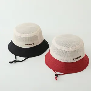 Détail de chapeaux d'été en maille avec broderie 'behappy' et cordons de serrage réglables