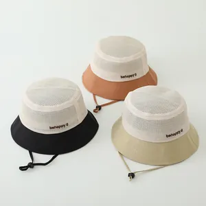 Détail de chapeaux de soleil respirants pour enfants en noir, marron et beige brodés