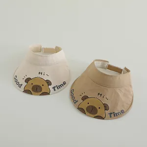 Detail of adjustable sun visor caps in beige and khaki with cute cartoon bear pattern