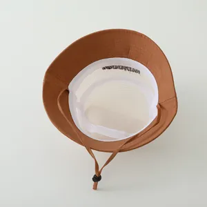 Detail of brown sun hat with breathable white mesh lining and adjustable windproof cord