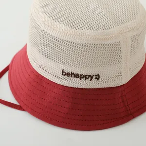 Détail du tissu en maille et broderie 'behappy' sur chapeau soleil pour enfant