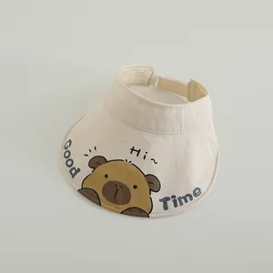 Detail of a creamy white kids' open top sun hat with cartoon bear print and adjustable strap