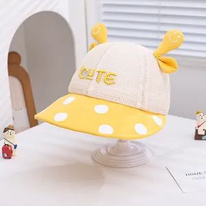 Detail of baby summer sun hat featuring breathable mesh, CUTE embroidery and yellow polka dots