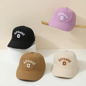 Detail of four quick-dry baby baseball caps in purple, black, brown, and beige colors
