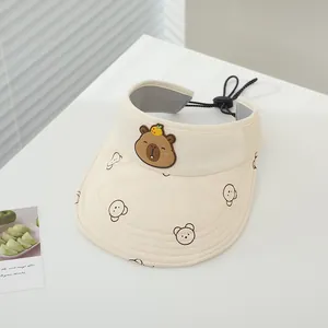 Vista dettagliata di un cappello da sole crema con toppa Capybara per bambini piccoli