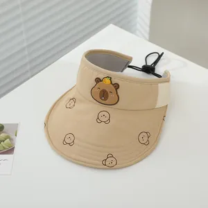 Dettaglio del cappello da sole kaki per bambini con motivo capibara e laccio regolabile