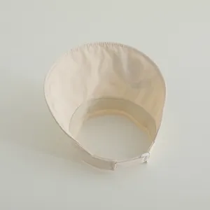 Detail view of the breathable sweatband and adjustable buckle on the beige sun visor