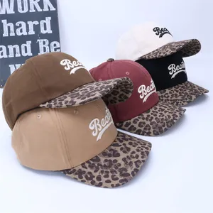 Macro detail of assorted baseball caps featuring leopard print brims and beauty embroidery