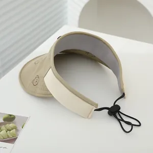 Dettaglio cappello parasole kaki a tesa larga con motivo orso e cinturino elastico