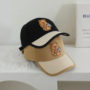 Detailed view of color-block baseball caps with 3D teddy bear patches and cotton texture