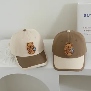 Close-up of children's baseball caps with cute bear patch and contrast color panels