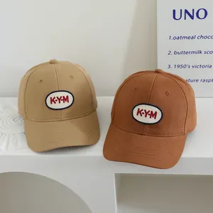 Detail von khakifarbenen und braunen Baumwoll-Basecaps mit KYM-Stickerei-Patch