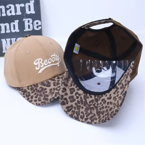 Detailed view of kids' leopard print baseball cap with embroidered letters and inner lining