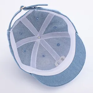 Inside view of light blue denim baseball cap with M embroidery and adjustable strap