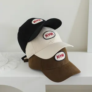 Detail der K-Y-M Stickerei auf Baumwoll-Basecaps in Schwarz, Beige und Braun für Kinder