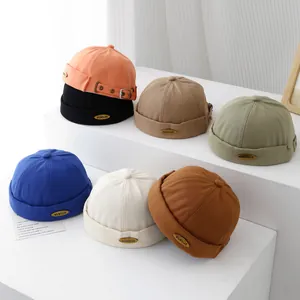 Dettaglio dei cappellini retrò in cotone per bambini con etichetta in metallo KUKUJI