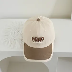 Detail of HELLO happiness embroidery on beige and brown kids baseball cap