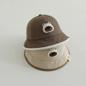 Detail view of quilted cotton baby bucket hats with cute bear embroidery patches