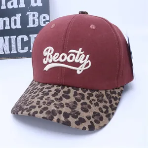 Detail of burgundy baseball cap with Beooty embroidery and leopard print brim
