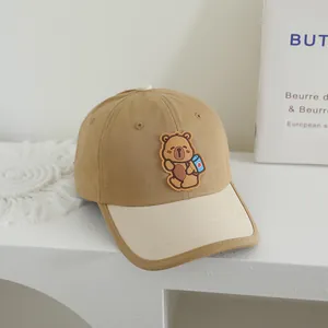 Close-up of khaki cotton baseball cap with cute bear patch and beige brim detail