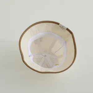 Detail of baby sun hat with breathable mesh lining, windproof strap and soft cotton label