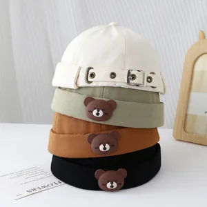 Vue détaillée de bonnets docker coton avec ours en beige, vert, marron et noir