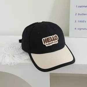 Detail of a kids baseball cap with HELLO patch embroidery and contrast brim