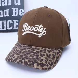 Detail of Beooty embroidery on brown canvas crown and leopard print brim of baseball cap