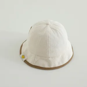Detailed macro view of the striped fabric texture and brown trim on the kid's sun hat