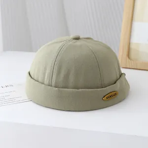 Dettaglio del cappello miki kaki con logo in metallo dorato e trama in twill di cotone