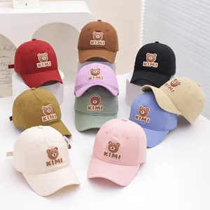 Close-up of nine colorful cotton baseball caps for kids featuring cute bear patches