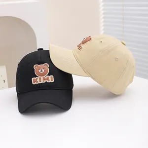 Detail of kids baseball caps featuring 3D bear patch and KIMI embroidery on fabric