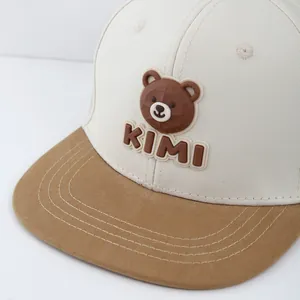Kids color-block flat brim baseball cap featuring a 3D KIMI bear patch on beige crown