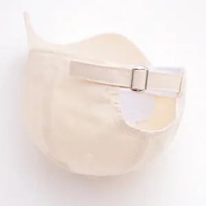 Detail view of adjustable back buckle and stitching on beige cotton baseball cap