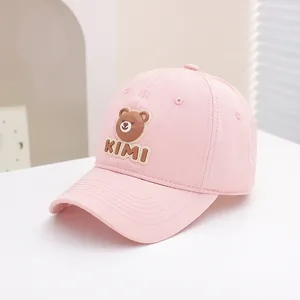 Detailed view of pink cotton baseball cap with 3D bear patch and KIMI embroidery