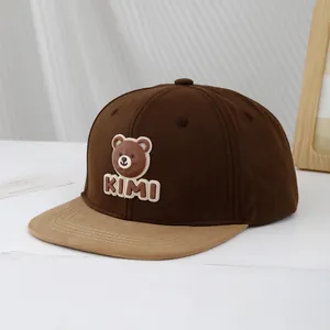 Detail of kids' baseball cap with brown bear silicone badge and KIMI lettering