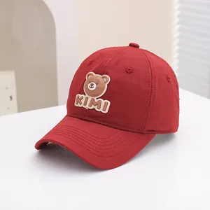 Detailed view of the red cotton baseball cap with 3D cartoon bear patch and KIMI text