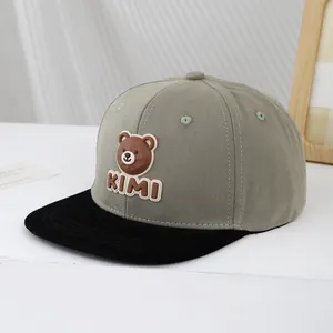 Close-up of the embroidered KIMI bear silicone patch on the cotton baseball cap