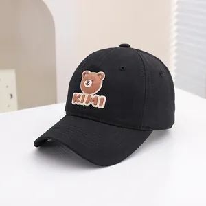 Close-up of black cotton kids baseball cap featuring a cute 3D brown bear and KIMI logo