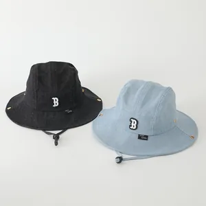 Detalle de gorros bucket de denim para niños con bordado B y cordones resistentes al viento