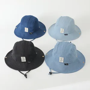Detalle de sombreros de pescador vaqueros para niños con cordón ajustable y parche de tela