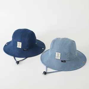Detalle de sombreros de pescador en denim con textura y cordones ajustables para viento