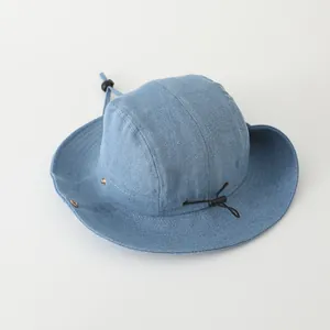 Detalle de gorro de mezclilla azul con cordón ajustable y ojales metálicos